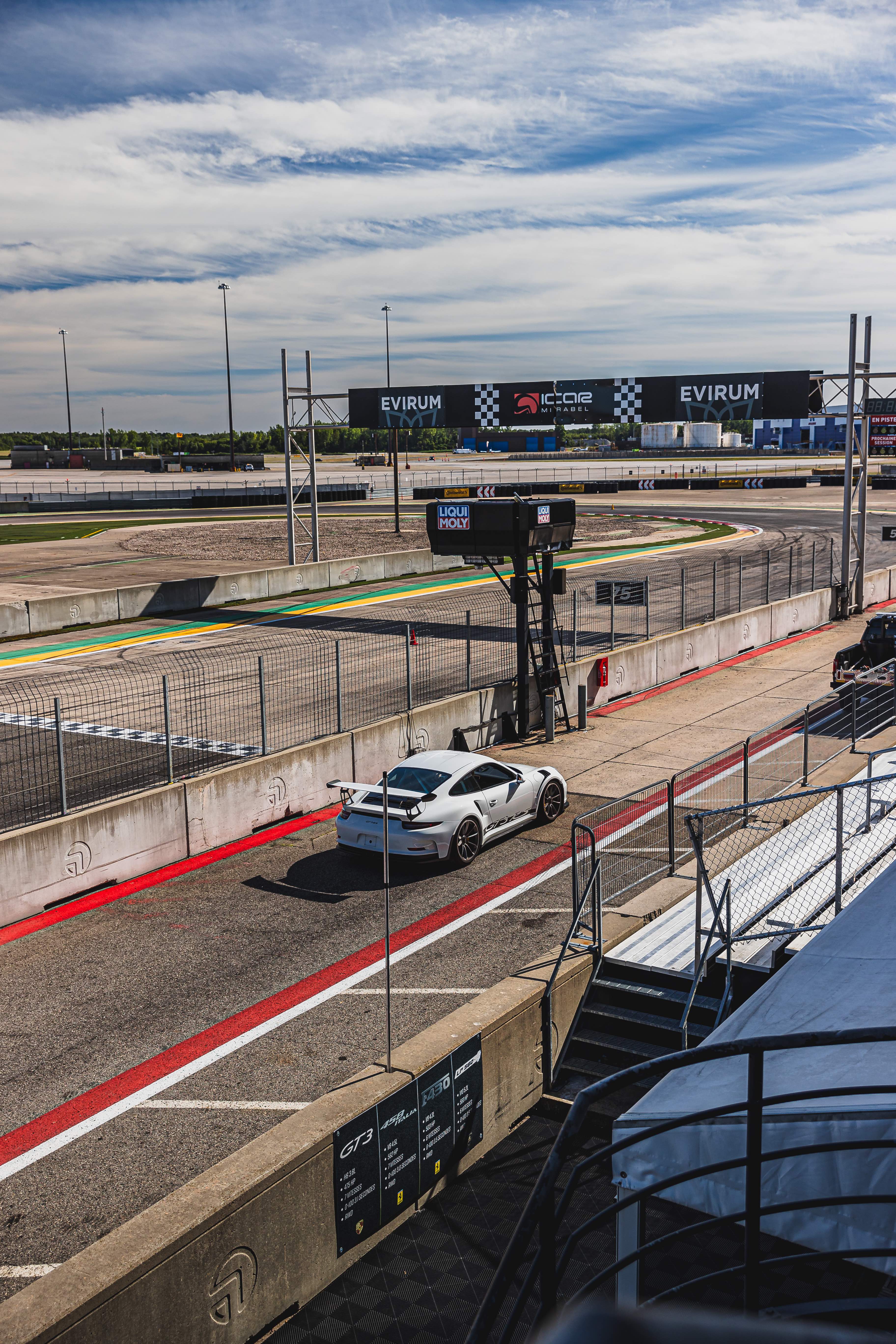 Voiture de course dans la voie des puits du Circuit ICAR
